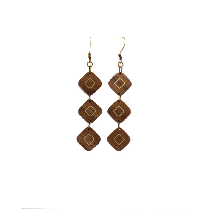 A pair of smoothed wooden drop earrings features three diamond pieces inlaid with bronze.  Each piece is handmade and unique. Placement and colors may vary and are not guaranteed but will resemble the piece shown.      2" long x 0.5" wide     Ear hook is bronze and nickle free.